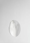 Silver round mirror-polished earring on a light gray background