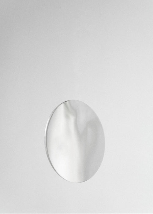Silver round mirror-polished earring on a light gray background