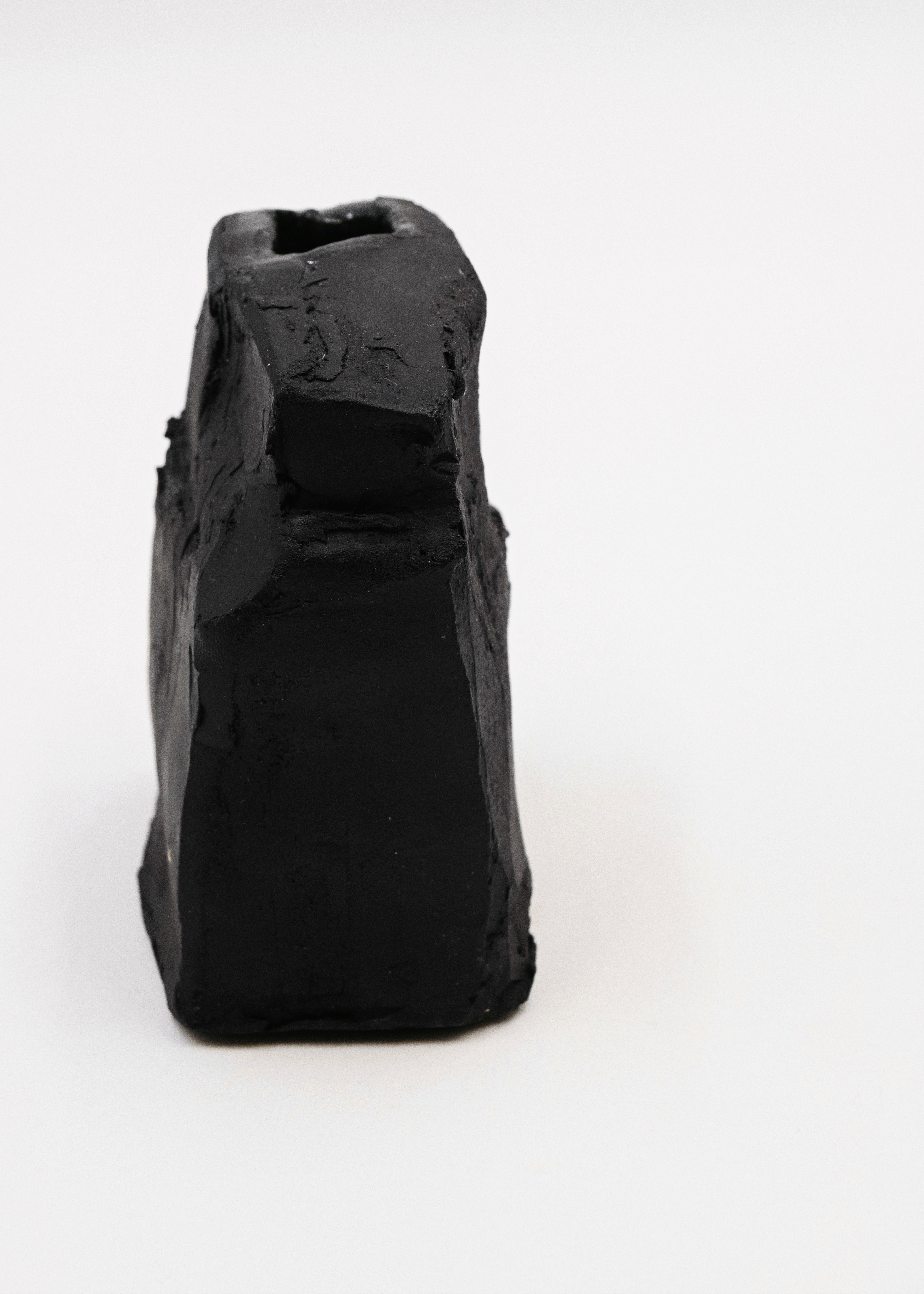 Black hand-carved vase on a white background
