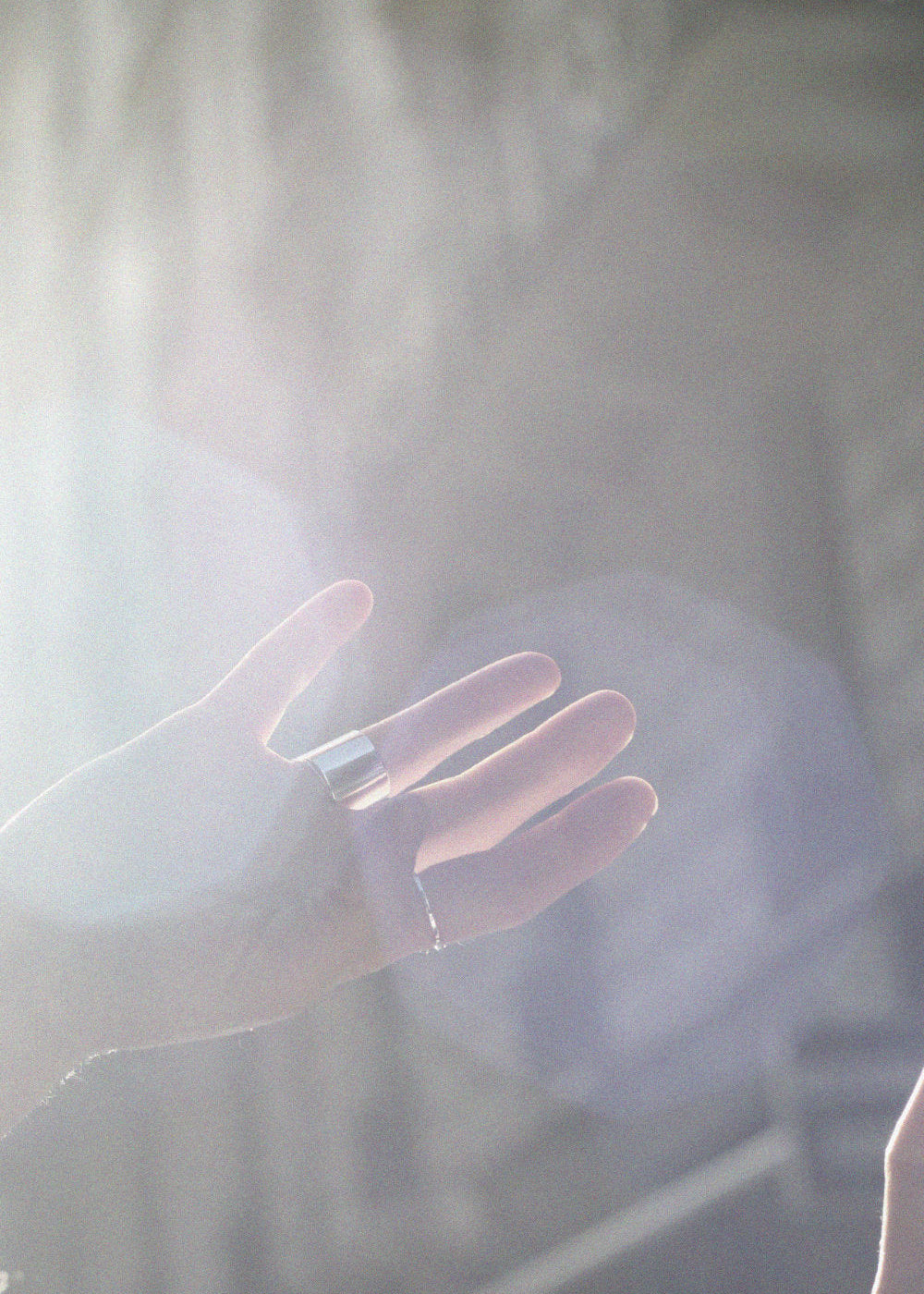 Hand with silver ring reaching out with a soft focus background of Paris houses