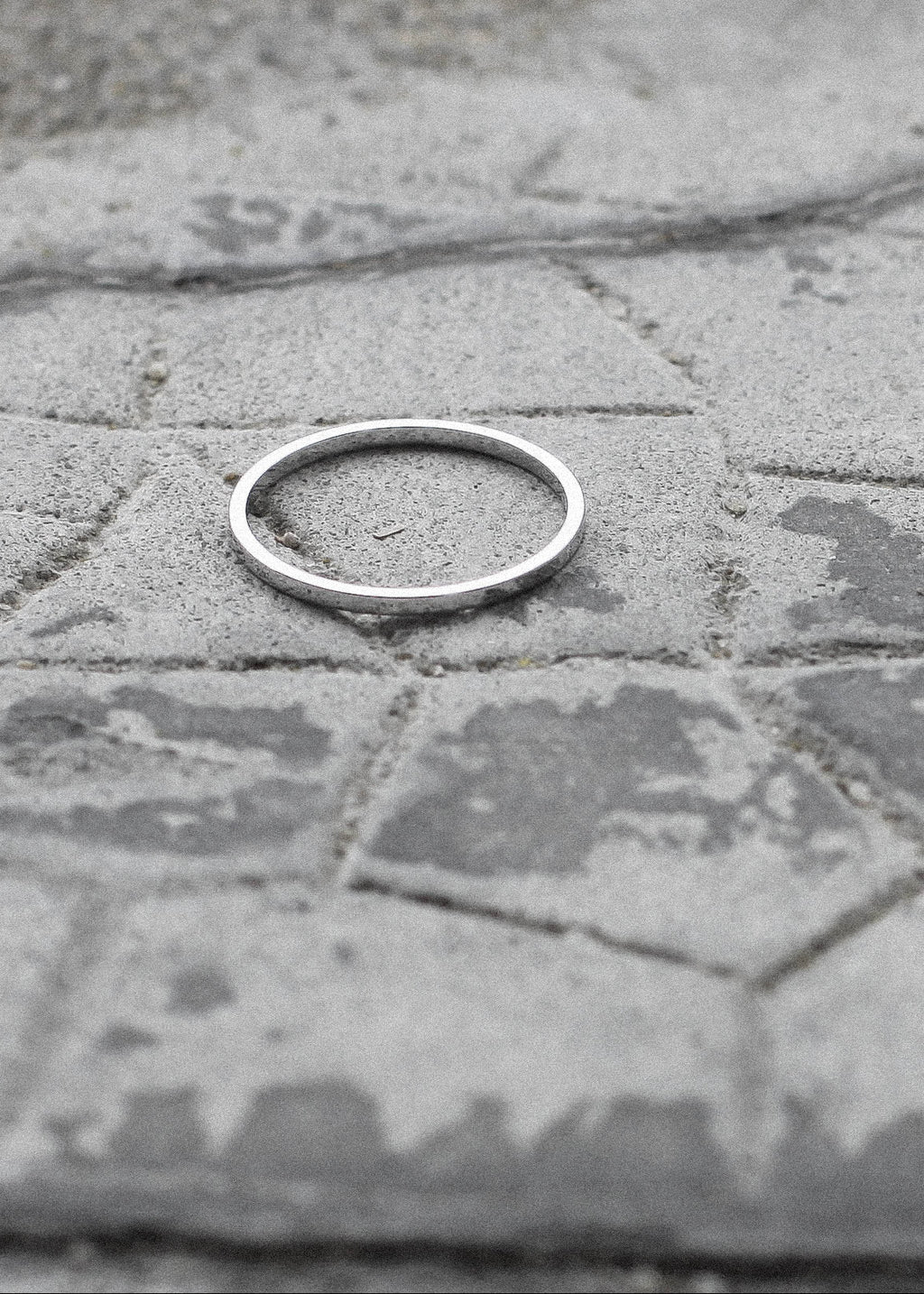 Silver ring on a textured stone surface