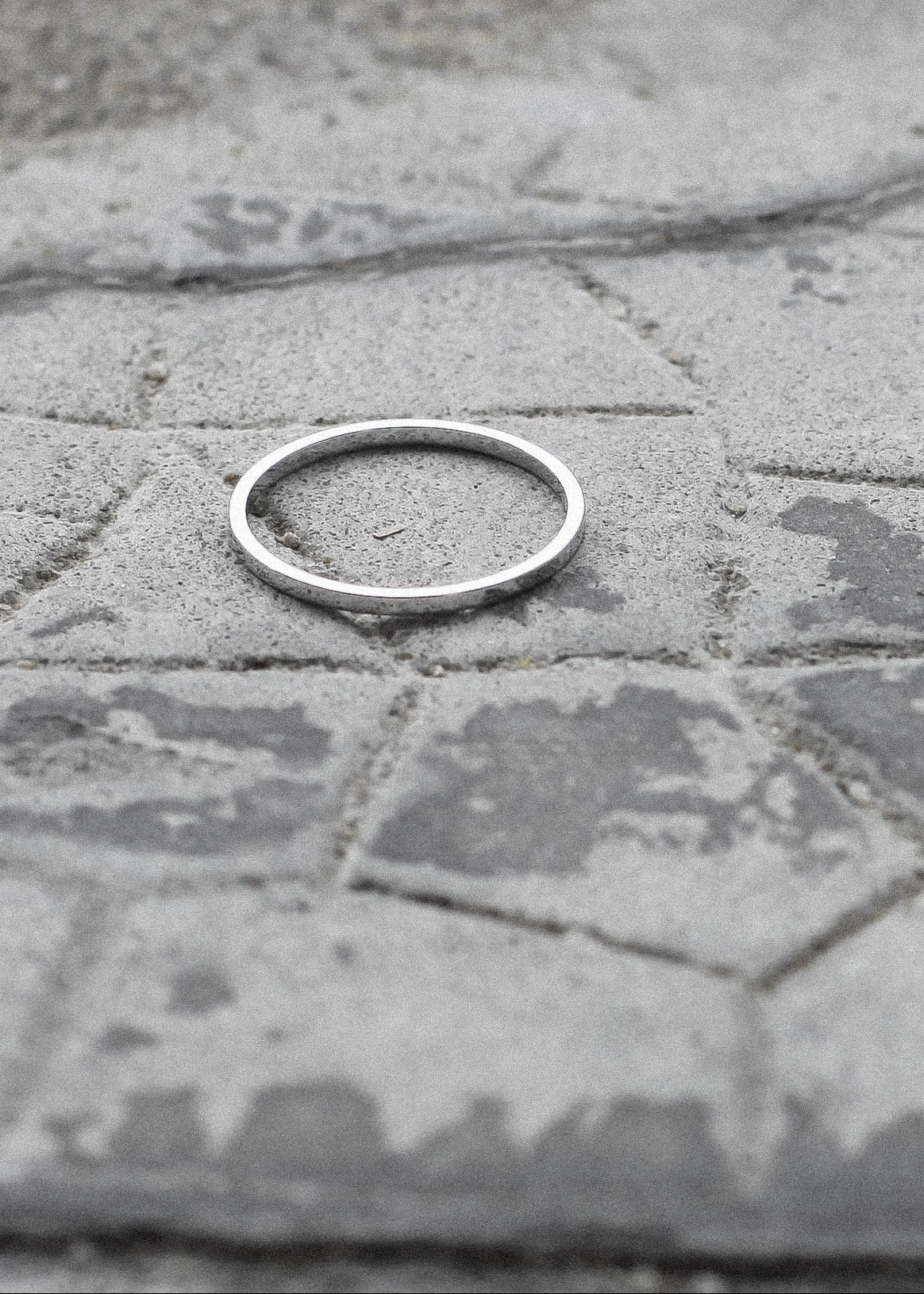 Silver ring on a textured stone surface