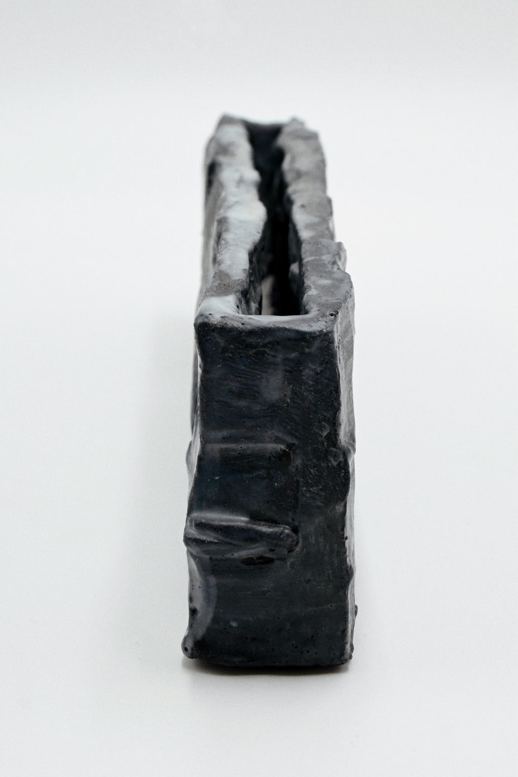nlack handcarved ceramic vessel on a white background