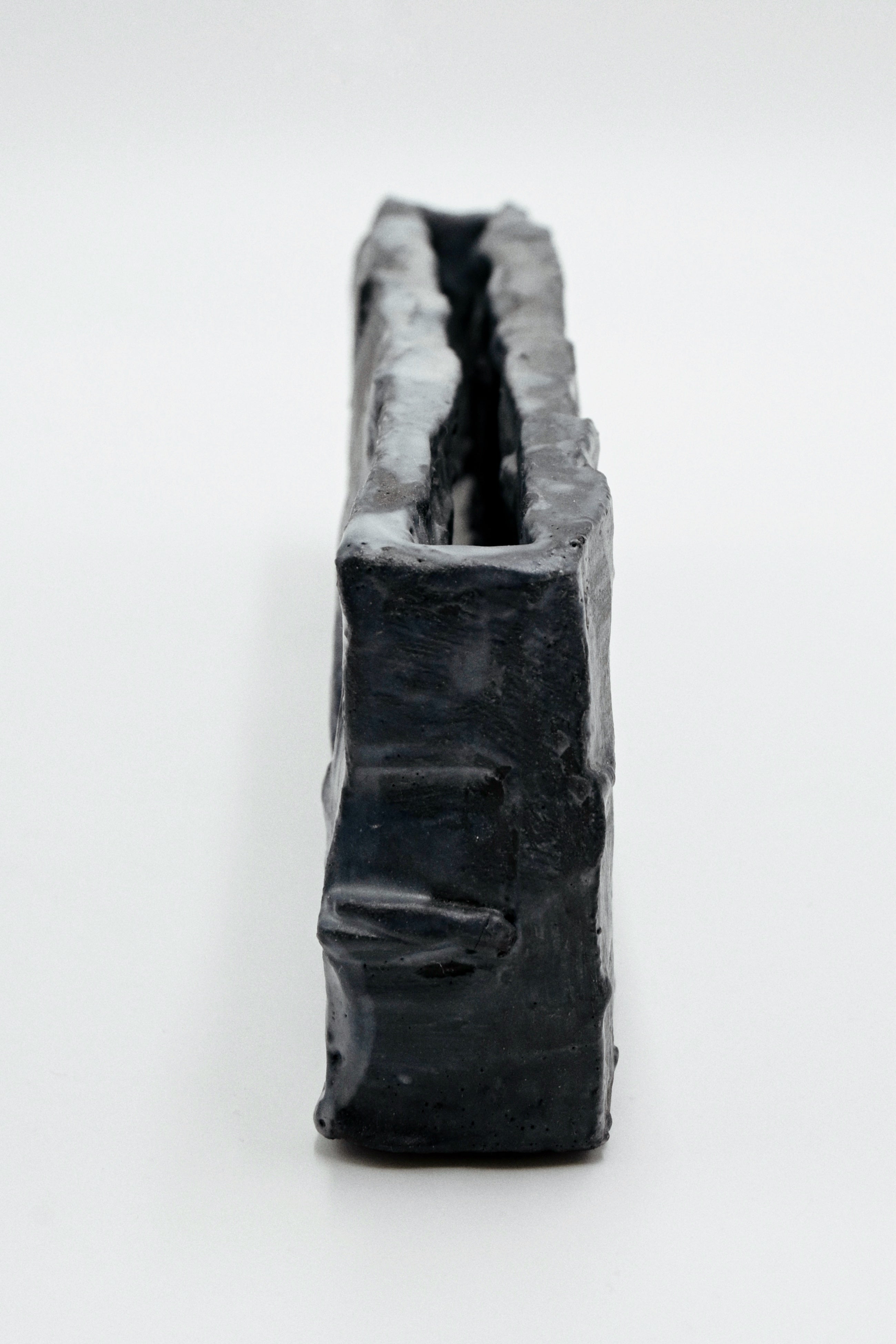 nlack handcarved ceramic vessel on a white background