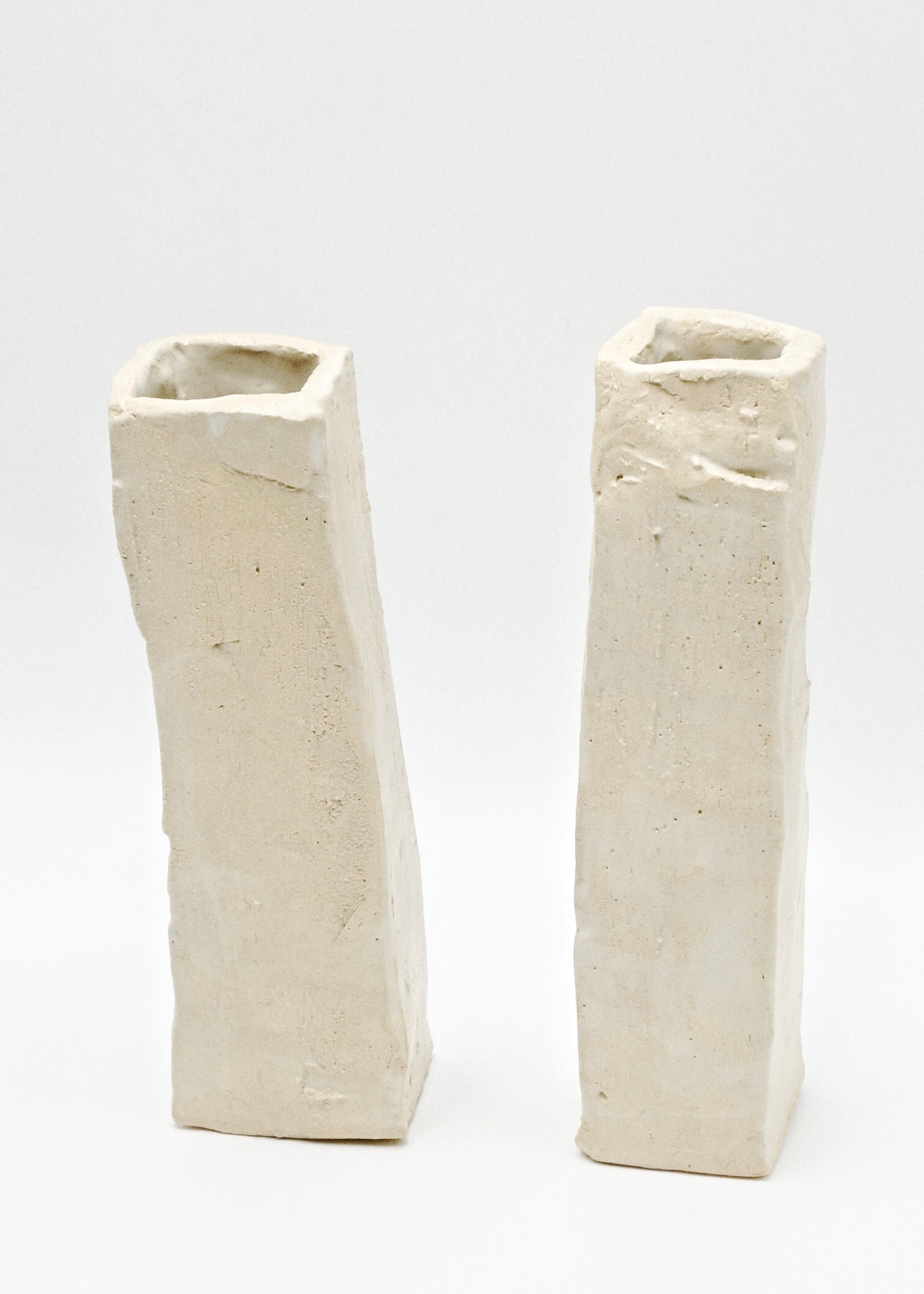 Two white ceramic vases on a light gray background