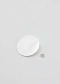 White circular earrings on a light gray background