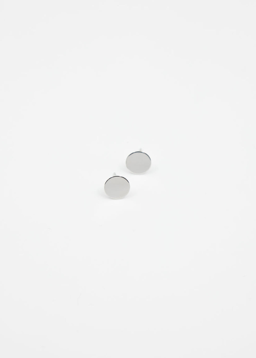 Pair of silver stud earrings on a light gray background