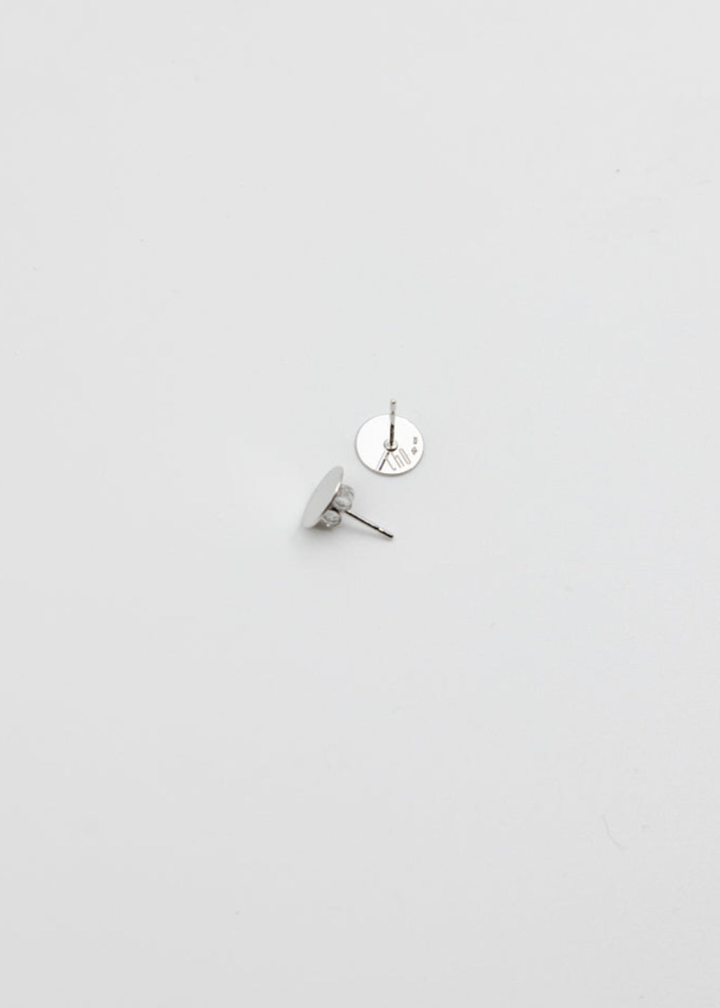 Silver earring on a light gray background