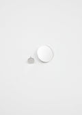 Two round mirror-polished silver earrings on a light gray background