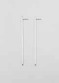 Two linear silver earrings on a light gray background