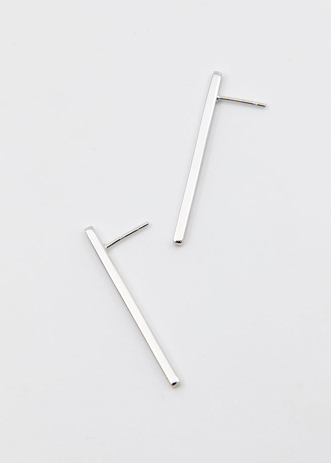 Two silver bar earrings on a light gray background
