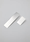 Two rectangular metallic earrings in different lengths on a gray background