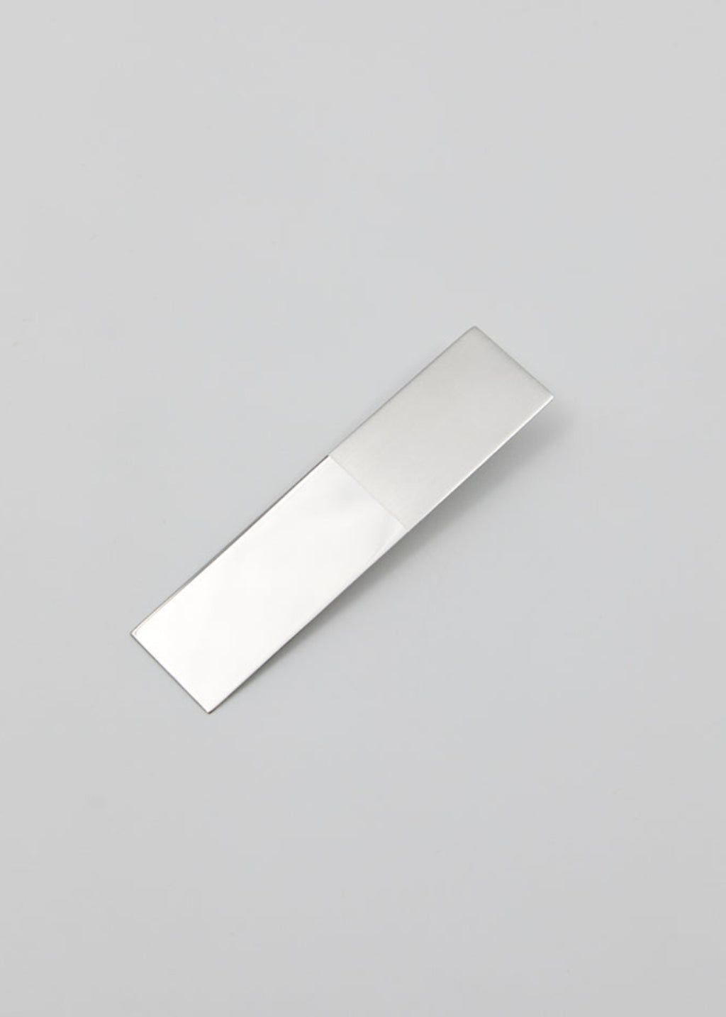 Rectangular silver earring on a light gray background