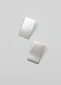 Two silver rectangular earrings on a light gray background