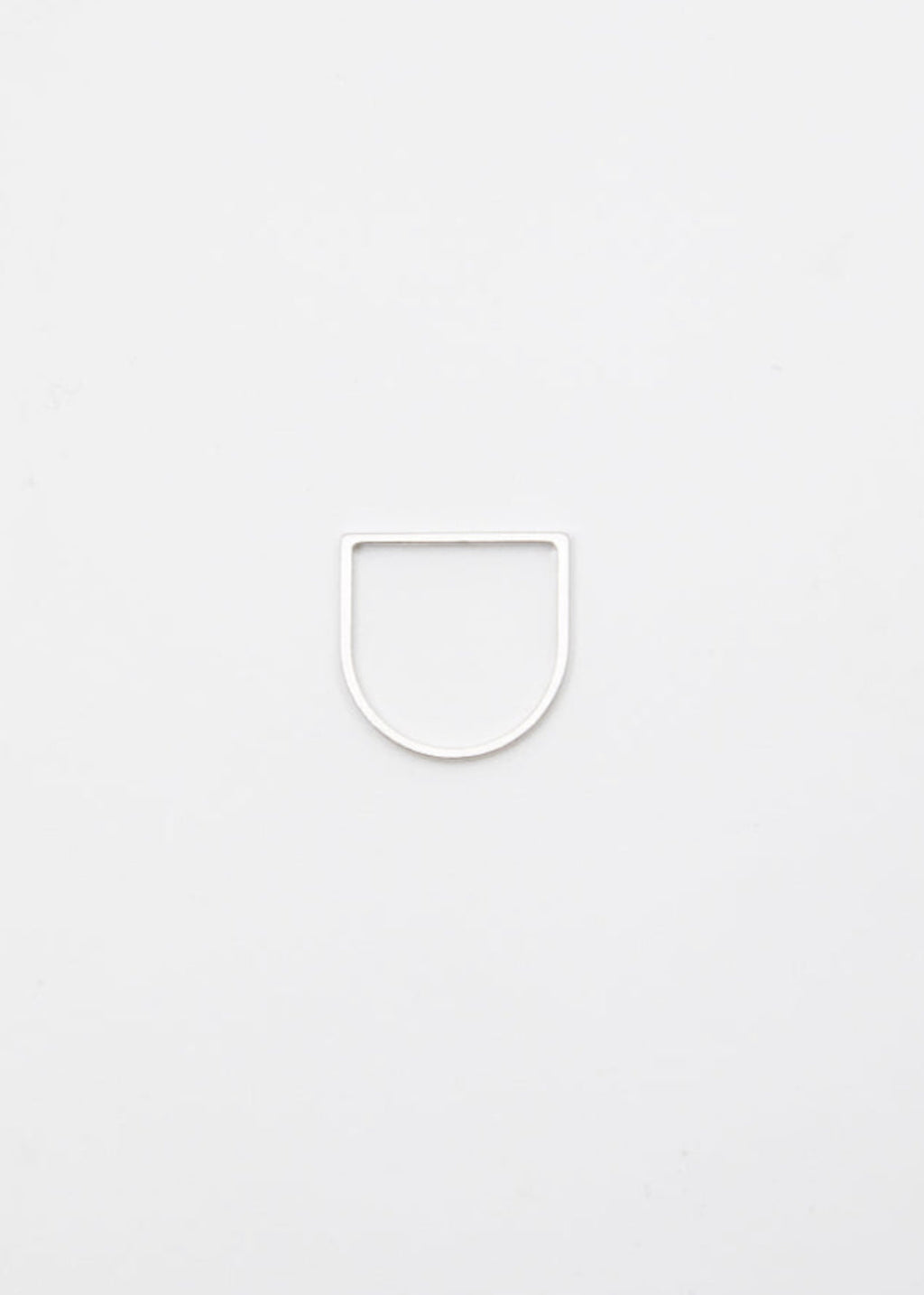 Thin linear silver ring on a light gray background
