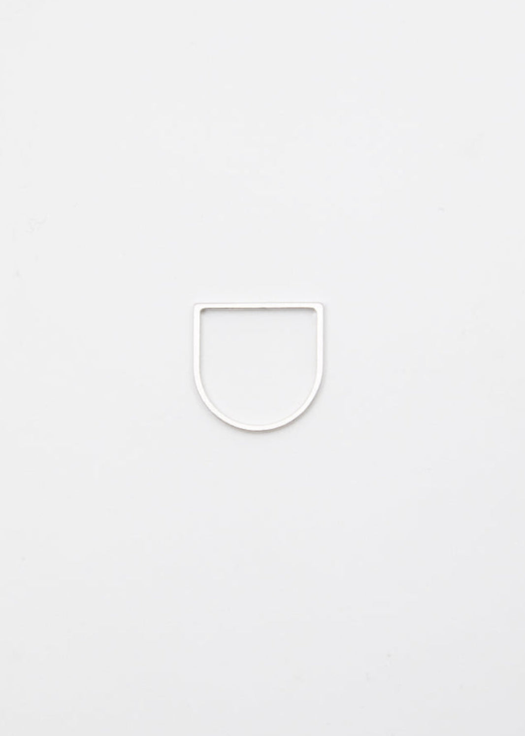 Thin linear silver ring on a light gray background